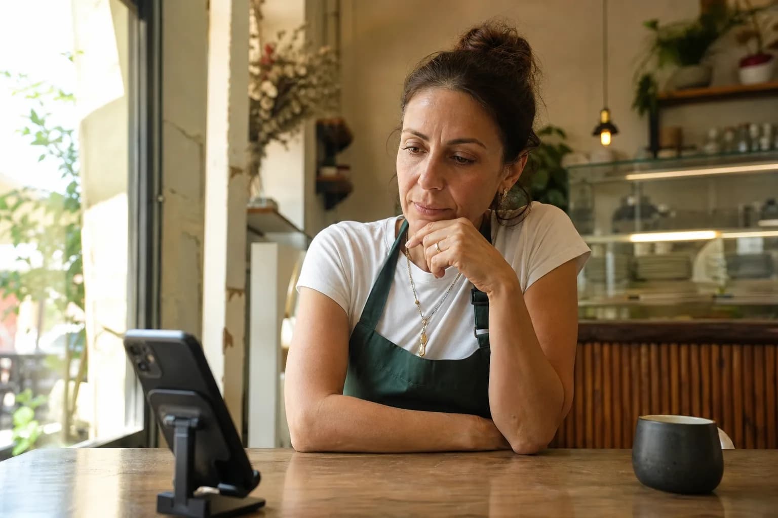 A small business owner analyzes her business's TikTok data at a coffee shop.
