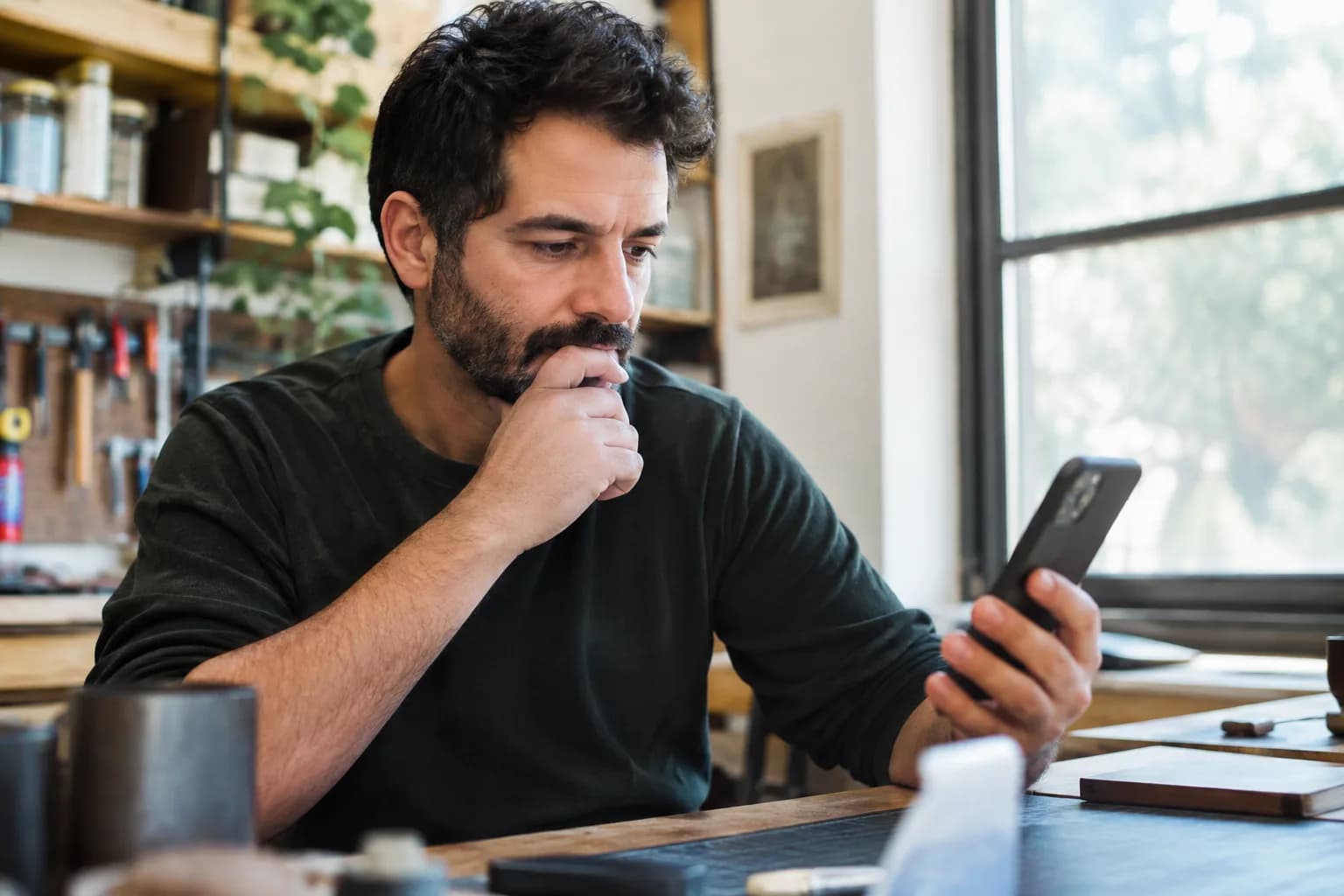 A small business owner checks hot trends on the TikTok app on his phone.
